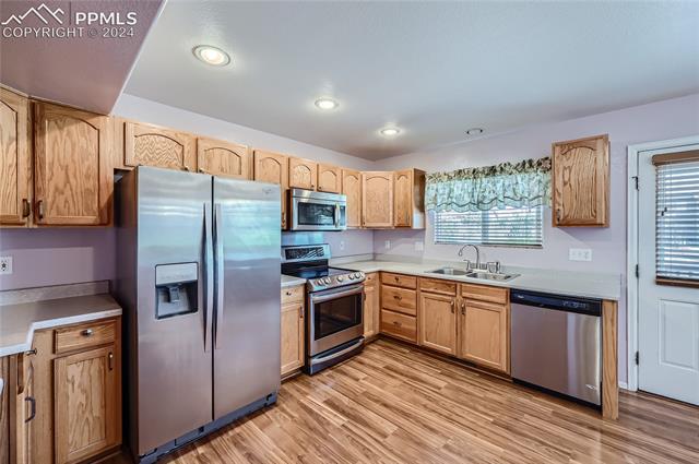 12510 Motley Road Peyton, CO 80831 - Photo 13 of 36 Kitchen with sink, light wood-type flooring, and appliances with stainless steel finishes