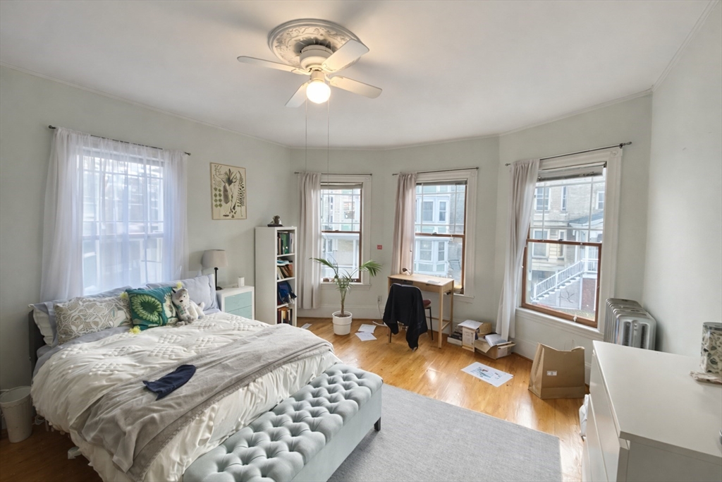 53 Hillside Street, Unit 2 Boston, MA 02120 - Photo 4 of 10 a bedroom with a large bed and a chandelier