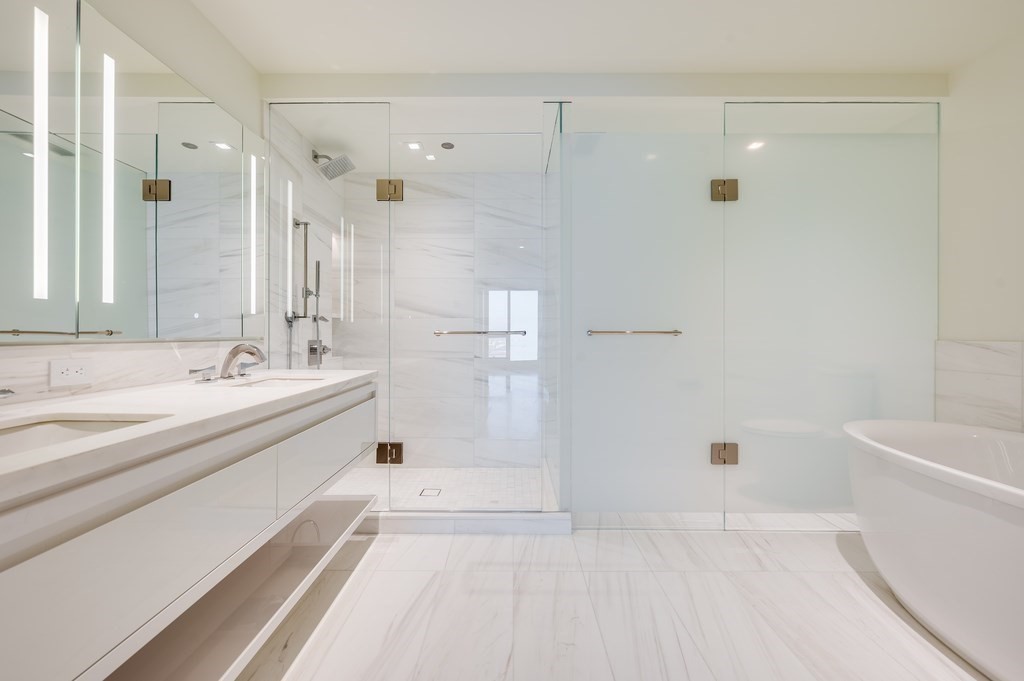 150 Seaport Boulevard, Unit 10D Boston, MA 02210 - Photo 5 of 23 a spacious bathroom with a bathtub shower sink and mirror