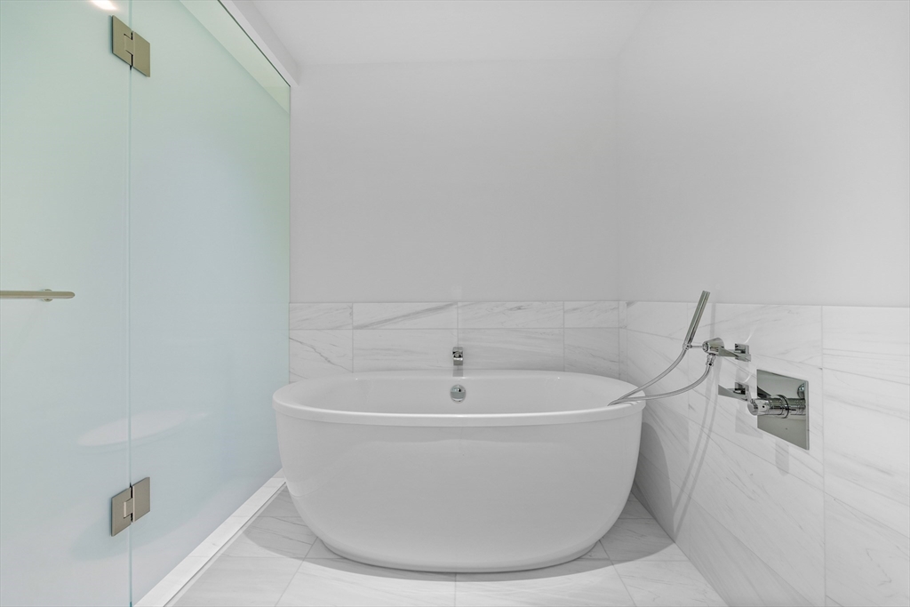 150 Seaport Boulevard, Unit 10D Boston, MA 02210 - Photo 6 of 23 a white bath tub sitting in a bathroom