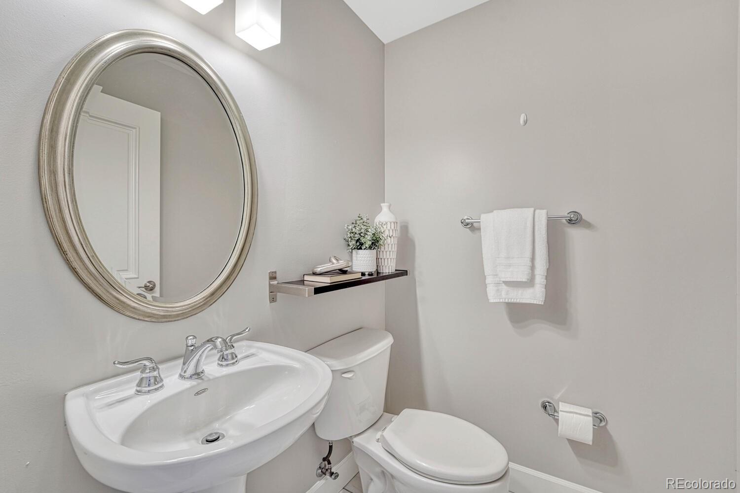 1975 Grant Street, Unit 509 Denver, CO 80203 - Photo 11 of 30 a bathroom with a toilet a sink and a mirror