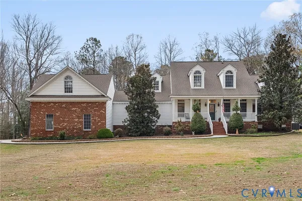 a front view of house with yard and trees in the background