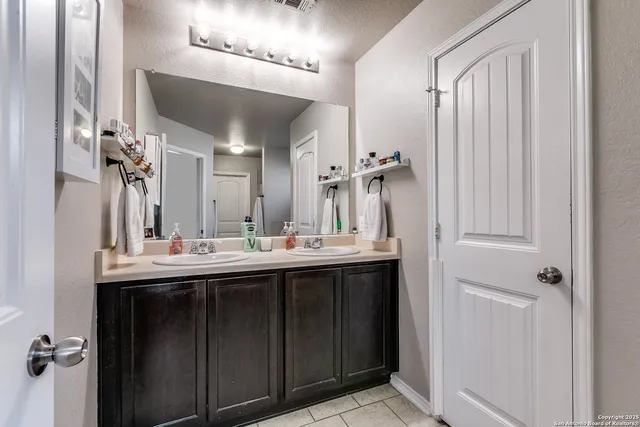 a bathroom with a double vanity sink and mirror