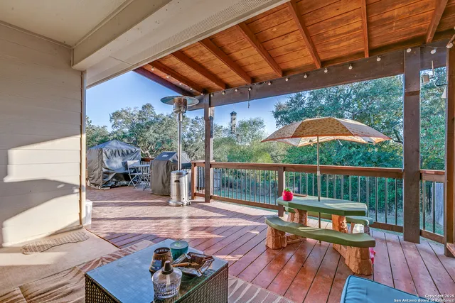 a balcony with wooden floor table and chairs