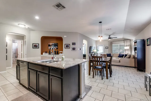 a dining hall with stainless steel appliances kitchen island a table and chairs