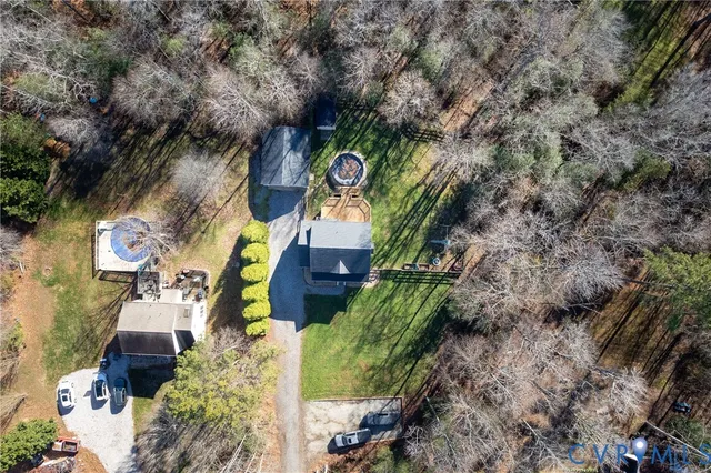 an aerial view of a house with a yard and large trees