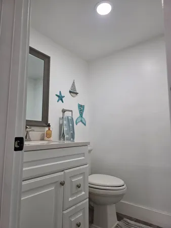 a bathroom with a toilet a sink and mirror