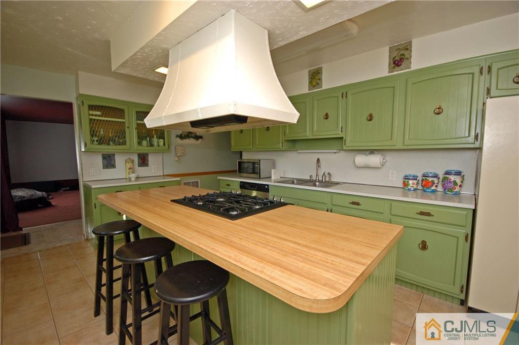 33 Stony Road Edison, NJ 08817 - Photo 11 of 25 a kitchen with kitchen island a stove a sink and a microwave