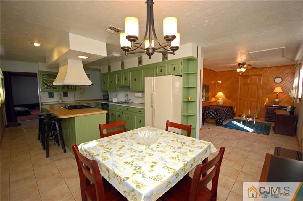 33 Stony Road Edison, NJ 08817 - Photo 15 of 25 a kitchen with stainless steel appliances kitchen island granite countertop a table chairs and a refrigerator