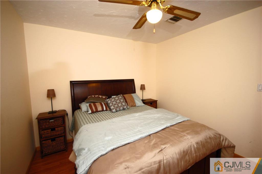 33 Stony Road Edison, NJ 08817 - Photo 5 of 25 a bedroom with a bed and a chandelier