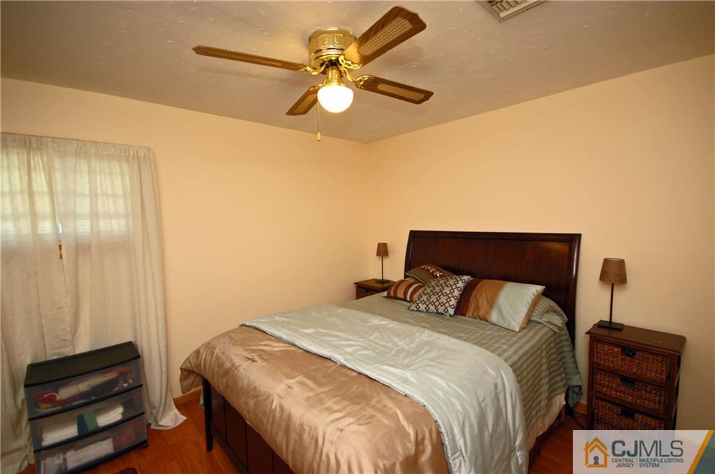 33 Stony Road Edison, NJ 08817 - Photo 6 of 25 a bedroom with a bed and a chandelier