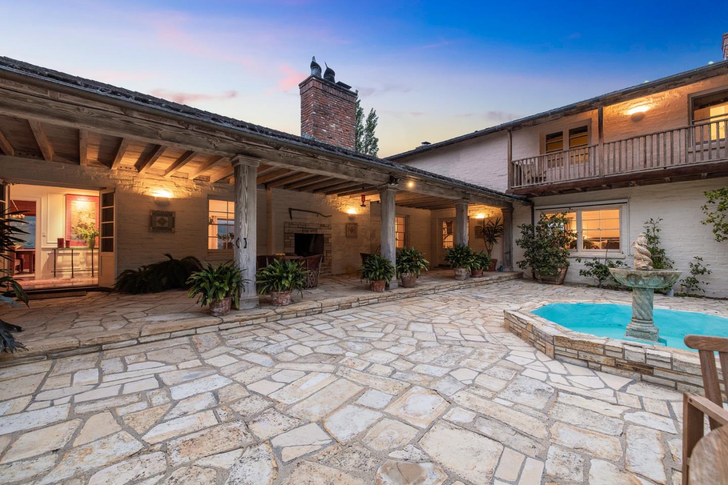 a view of a porch with a table and chairs under an umbrella