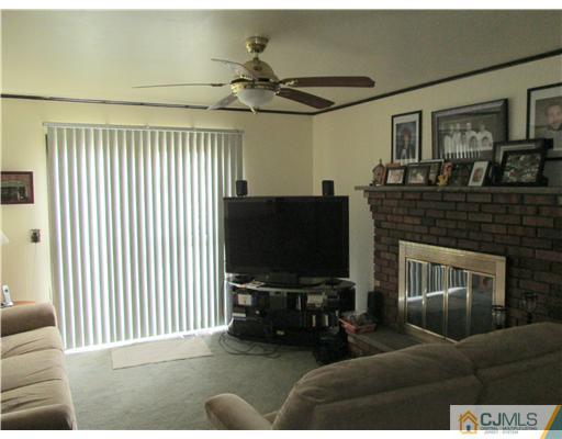 120 South Cliff Road Colonia, NJ 07067 - Photo 11 of 13 a living room with furniture a flat screen tv and a fireplace