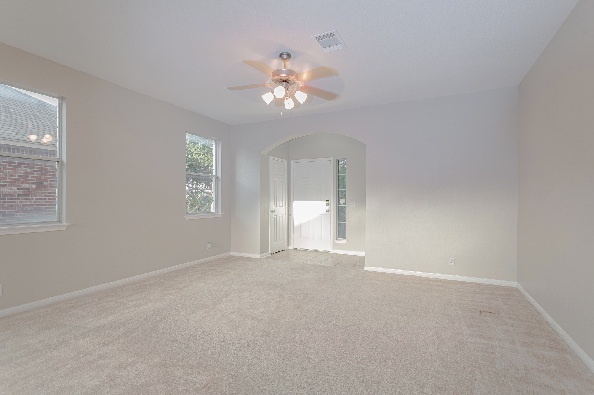 19201 Mangan Way Pflugerville, TX 78660 - Photo 12 of 29 Unfurnished room featuring light colored carpet, arched walkways, and a ceiling fan