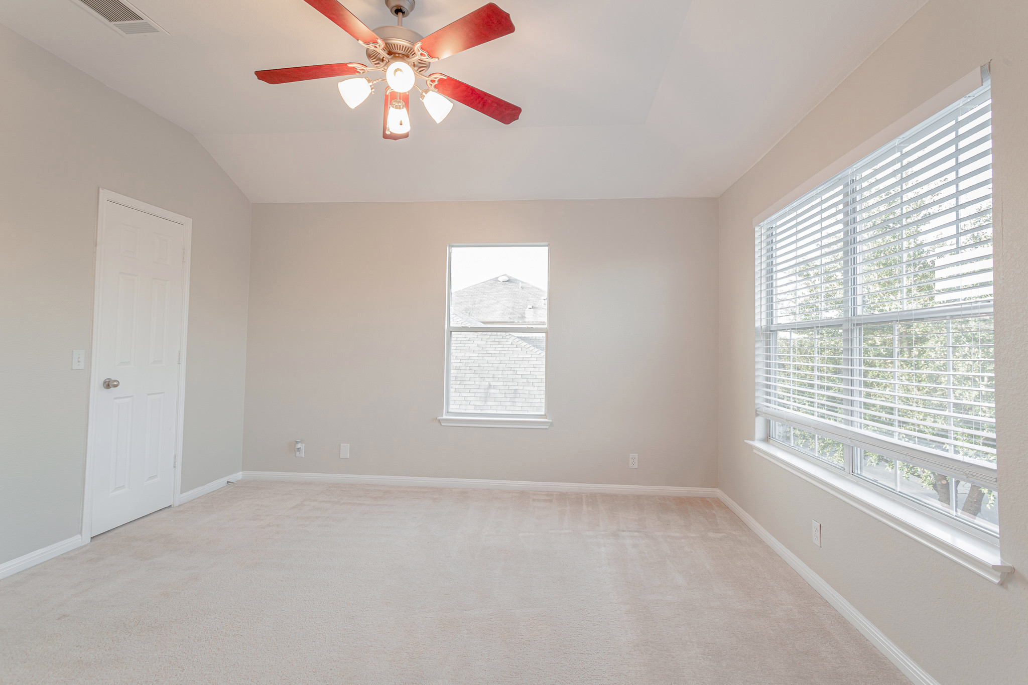 19201 Mangan Way Pflugerville, TX 78660 - Photo 16 of 29 Spare room featuring light carpet, a ceiling fan, and vaulted ceiling
