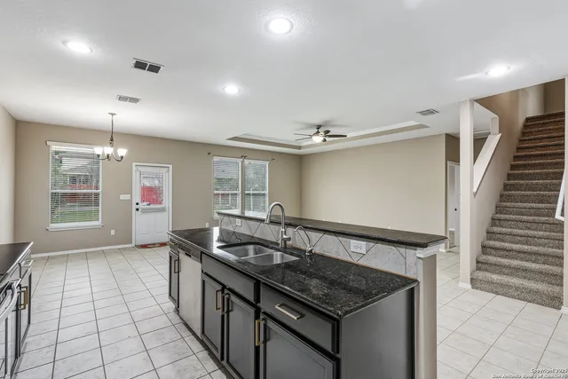 a kitchen with granite countertop a sink and a stove