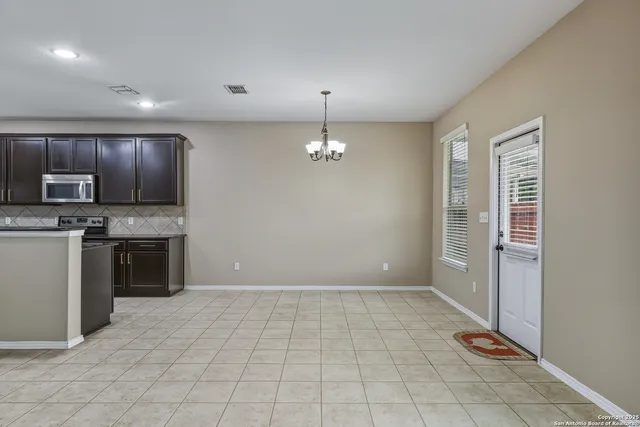a view of kitchen with granite countertop cabinets and refrigerator
