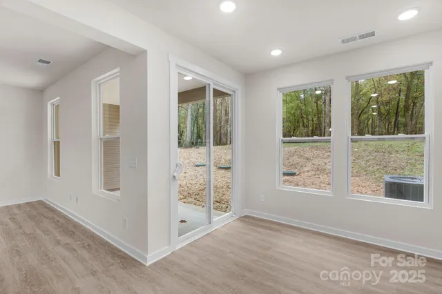 a view of an empty room with glass door and windows