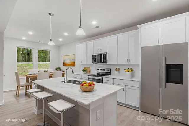 a kitchen with a refrigerator a stove a dining table and chairs