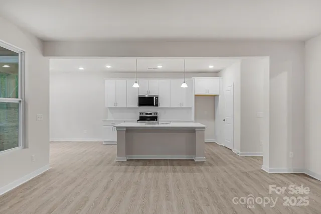 a view of kitchen with granite countertop stainless steel appliances refrigerator sink and stove
