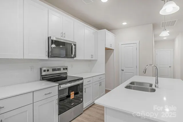 a kitchen with a sink a stove and cabinets