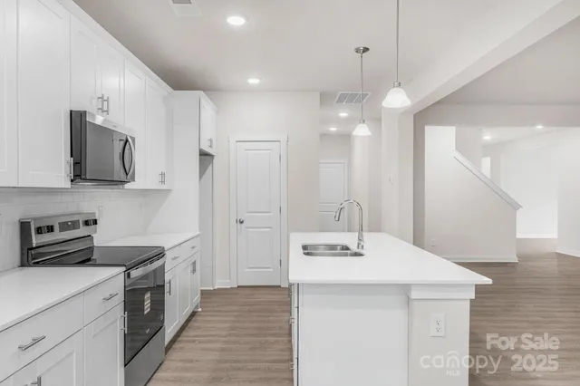 a kitchen with kitchen island a sink stainless steel appliances and cabinets