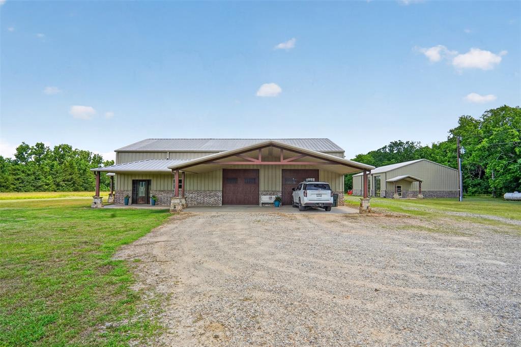 1524 County Road Sumner, TX 75486 - Photo 5 of 35 Metal-sided structure featuring a covered entry porch with stone accents and a carport