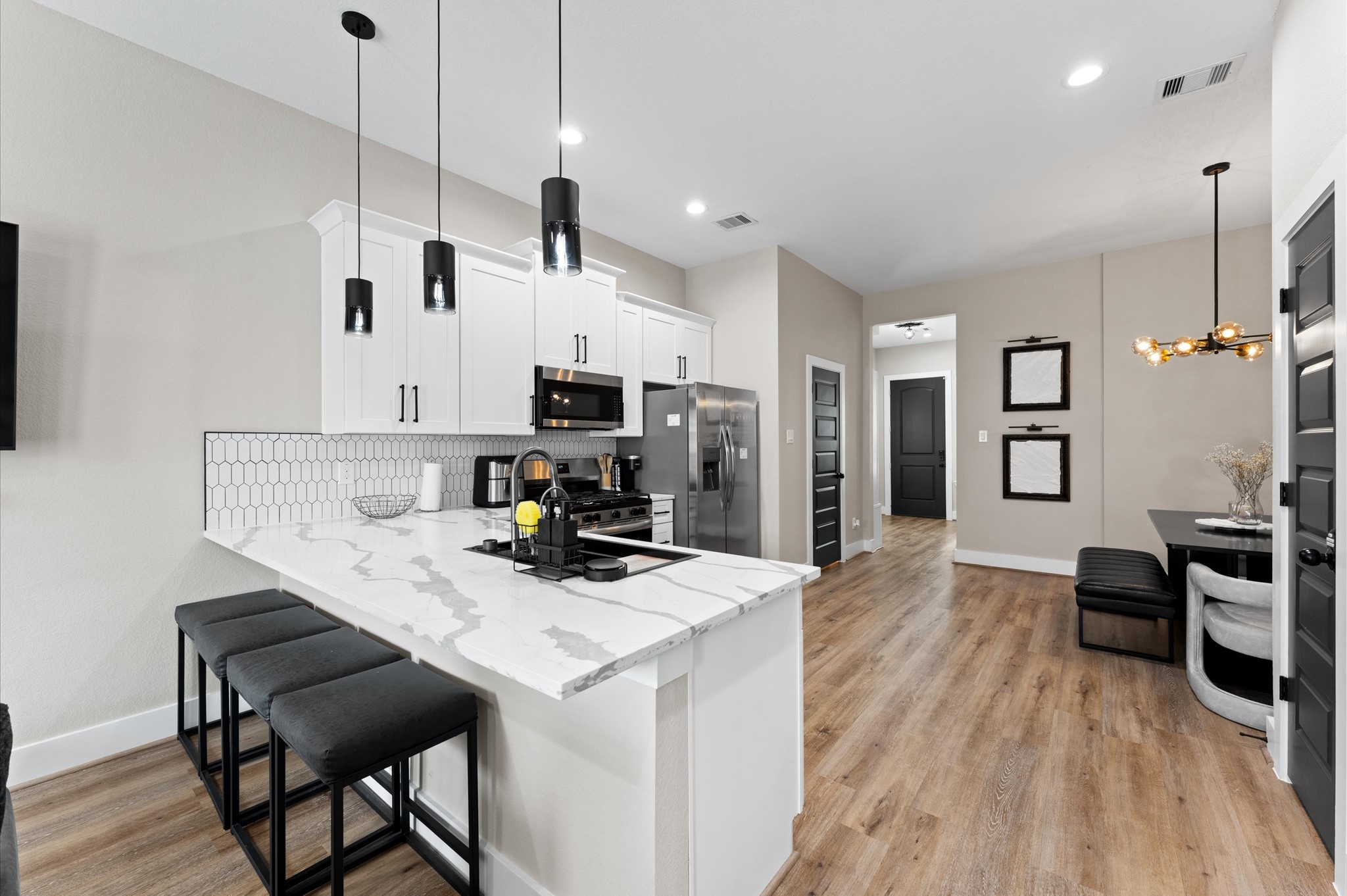 6904 Covington Drive, Unit B Houston, TX 77091 - Photo 12 of 47 a kitchen with a table chairs refrigerator and microwave