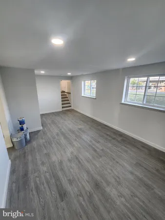 a view of empty room with wooden floor and window