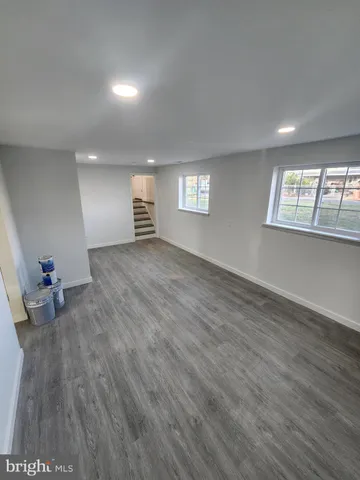 a view of empty room with wooden floor and window