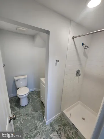 a bathroom with a toilet and a shower