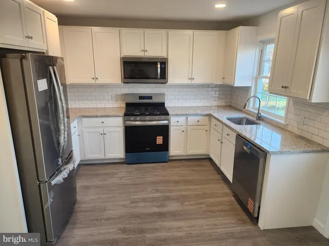 a kitchen with stainless steel appliances a refrigerator sink and microwave