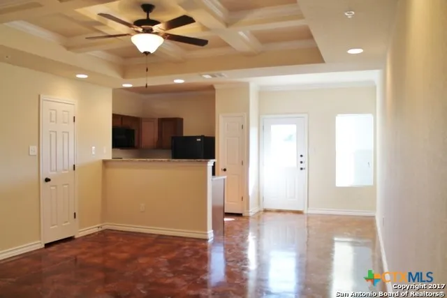 a view of a hallway with wooden floor and a ceiling fan