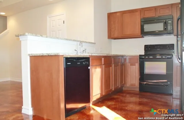 a kitchen with stainless steel appliances granite countertop a refrigerator and a sink