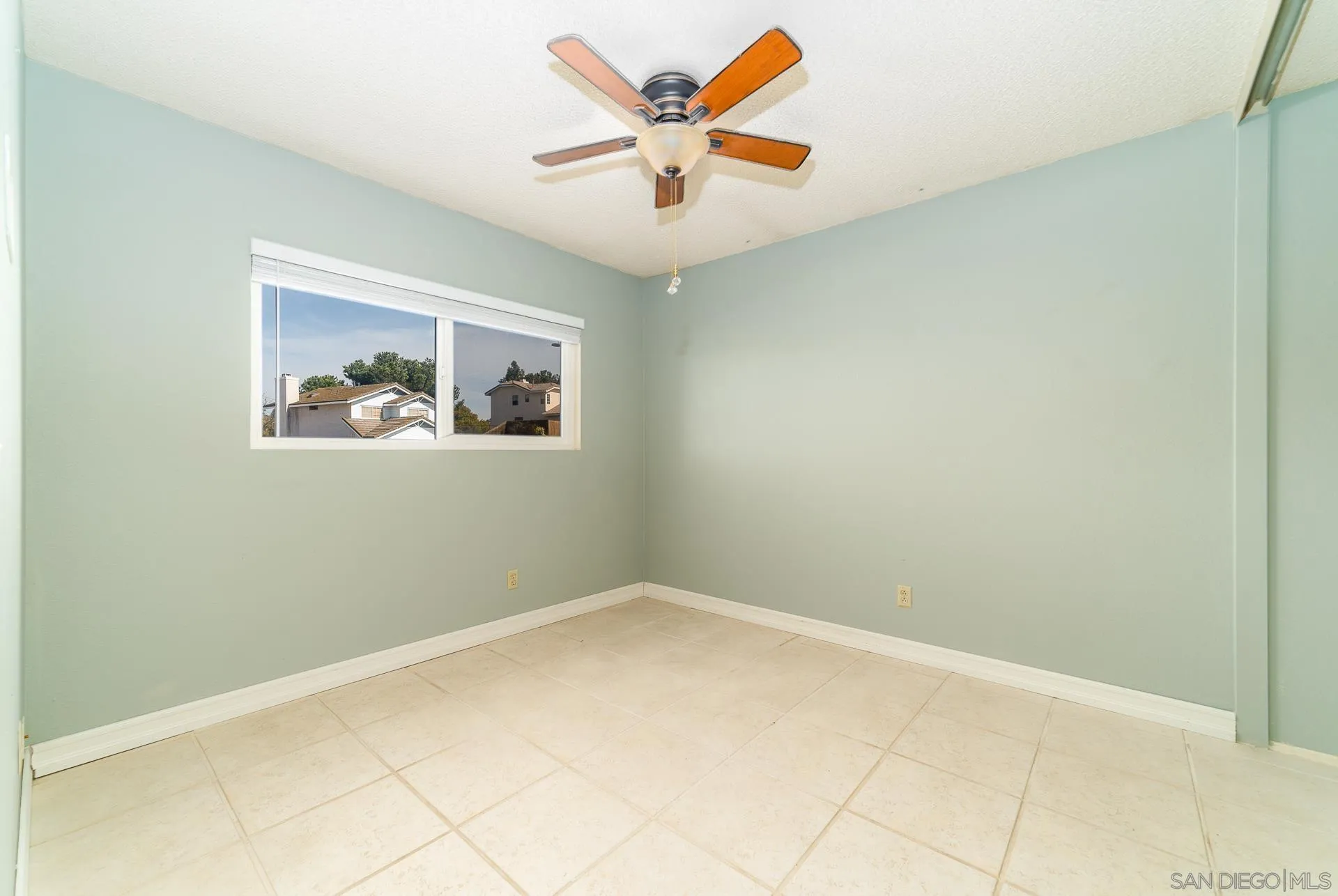 5268 Champlain Street Oceanside, CA 92056 - Photo 30 of 40 an empty room with a window and a ceiling fan