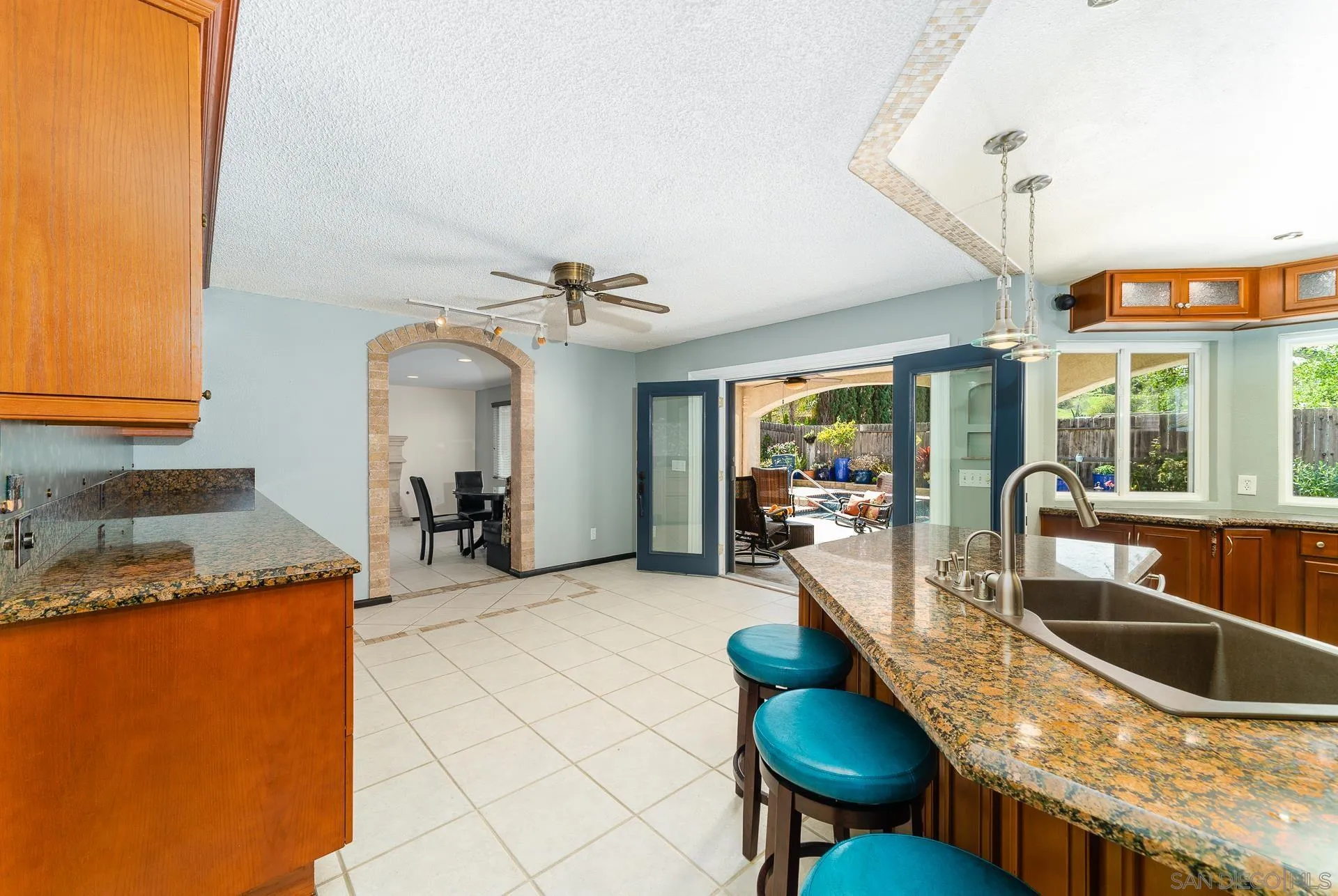 5268 Champlain Street Oceanside, CA 92056 - Photo 10 of 40 a kitchen with granite countertop a sink a counter top space and living room area