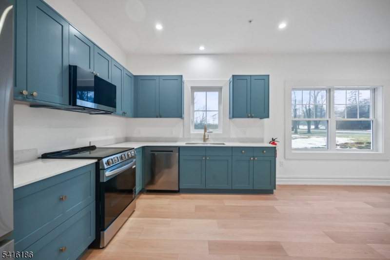 1209 Littleton Road, Unit C Morris Plains, NJ 07950 - Photo 4 of 15 a kitchen with stainless steel appliances granite countertop a stove a sink and a microwave