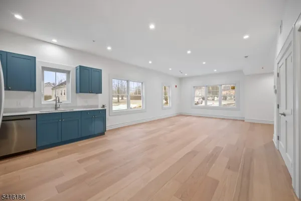 a large kitchen with stainless steel appliances granite countertop a large counter top a sink and a refrigerator