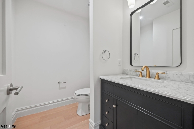 1209 Littleton Road, Unit C Morris Plains, NJ 07950 - Photo 10 of 15 a bathroom with a granite countertop sink a toilet and a mirror