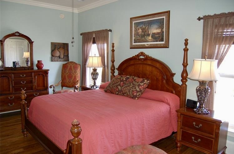 210 West Washington Street, Unit 210 Madison, GA 30650 - Photo 4 of 8 a bedroom with bed and wooden floor