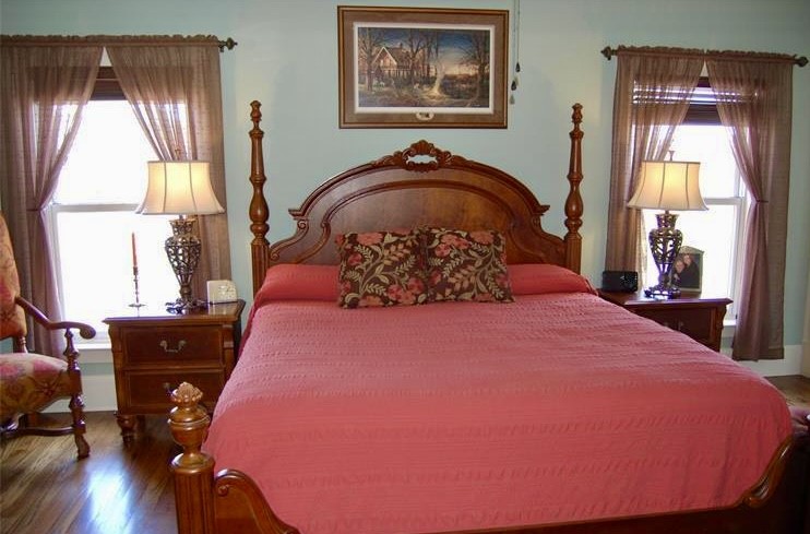 210 West Washington Street, Unit 210 Madison, GA 30650 - Photo 6 of 8 a bedroom with a bed and wooden floor