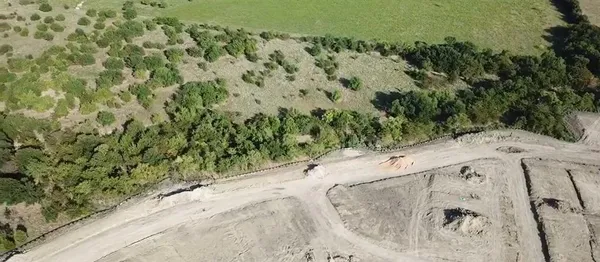 a view of a dry yard with wooden fence