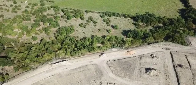 a view of a dry yard with wooden fence