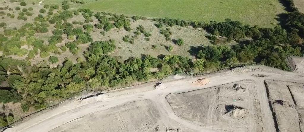 a view of a dry yard with wooden fence