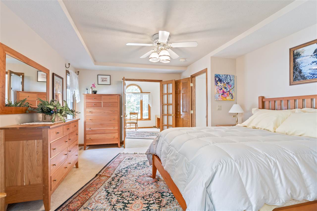 7272 Sentinel Road Rockford, IL 61107 - Photo 26 of 40 a spacious bedroom with a large bed and a chandelier