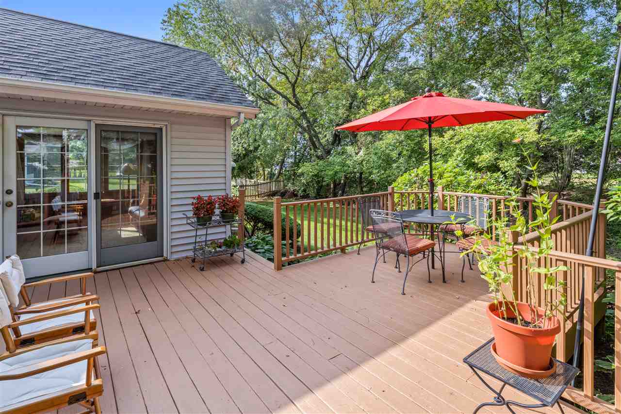 7272 Sentinel Road Rockford, IL 61107 - Photo 35 of 40 a view of a roof deck with table and chairs under an umbrella with wooden floor