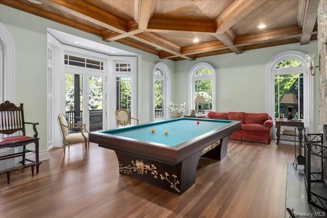 a living room with furniture pool table wooden floor and furniture