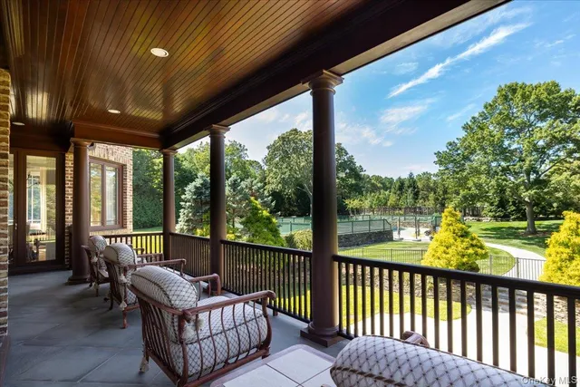 a view of a two chairs in the balcony next to a yard