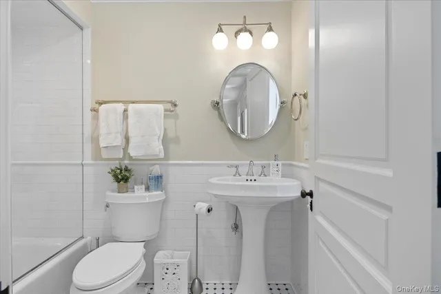 a bathroom with a toilet a sink and mirror