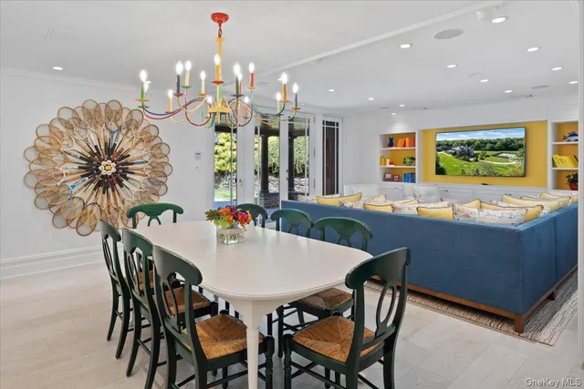 a dining room filled chandelier and wooden floor